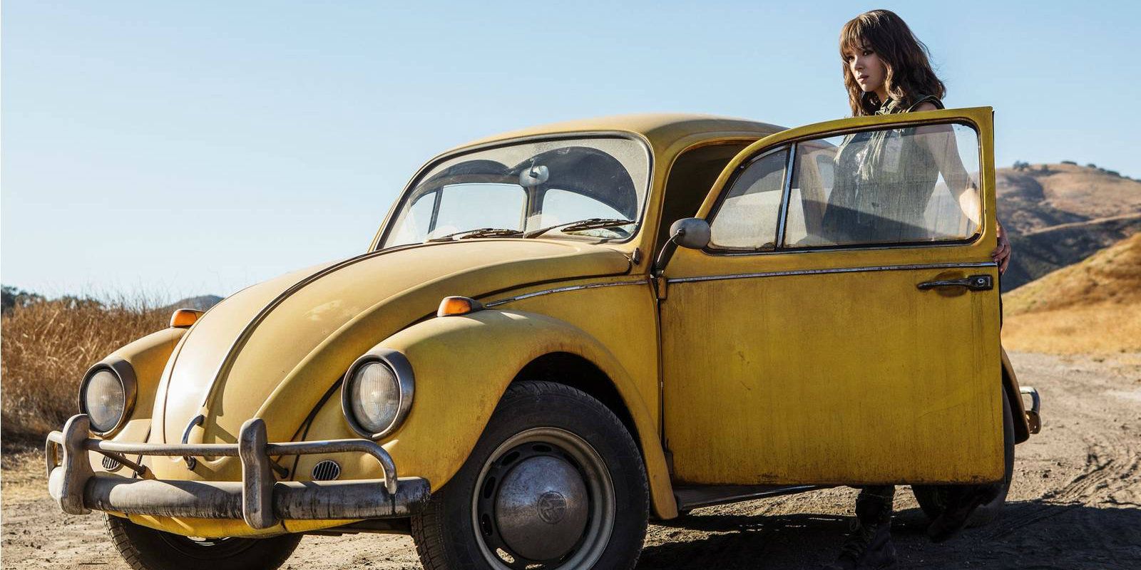 Hailee Steinfeld as Charlie standing outside Bumblebee's car in the Bumblebee Movie