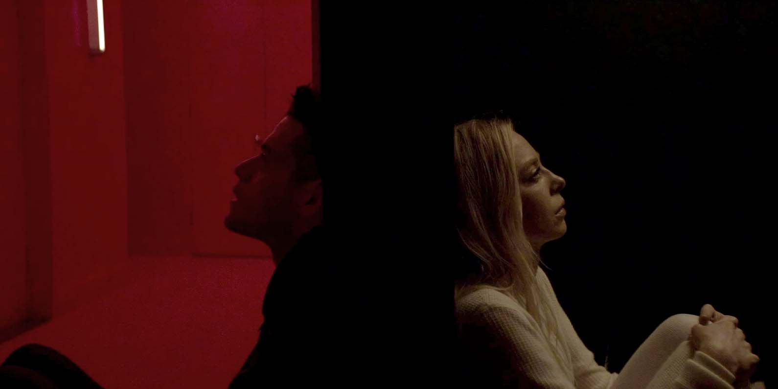Elliot and Angela sitting back to back in the dark in Mr. Robot.