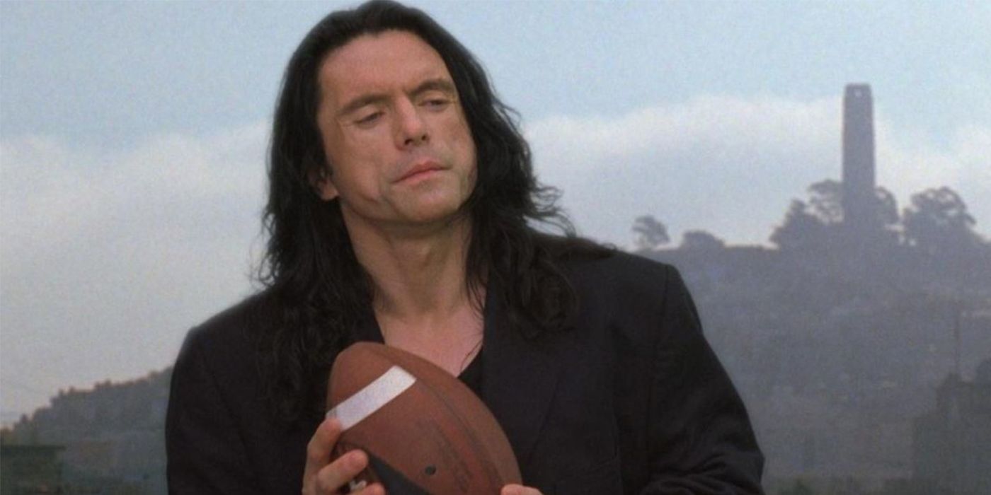 Johnny holds a football with the skyline behind him from The Room