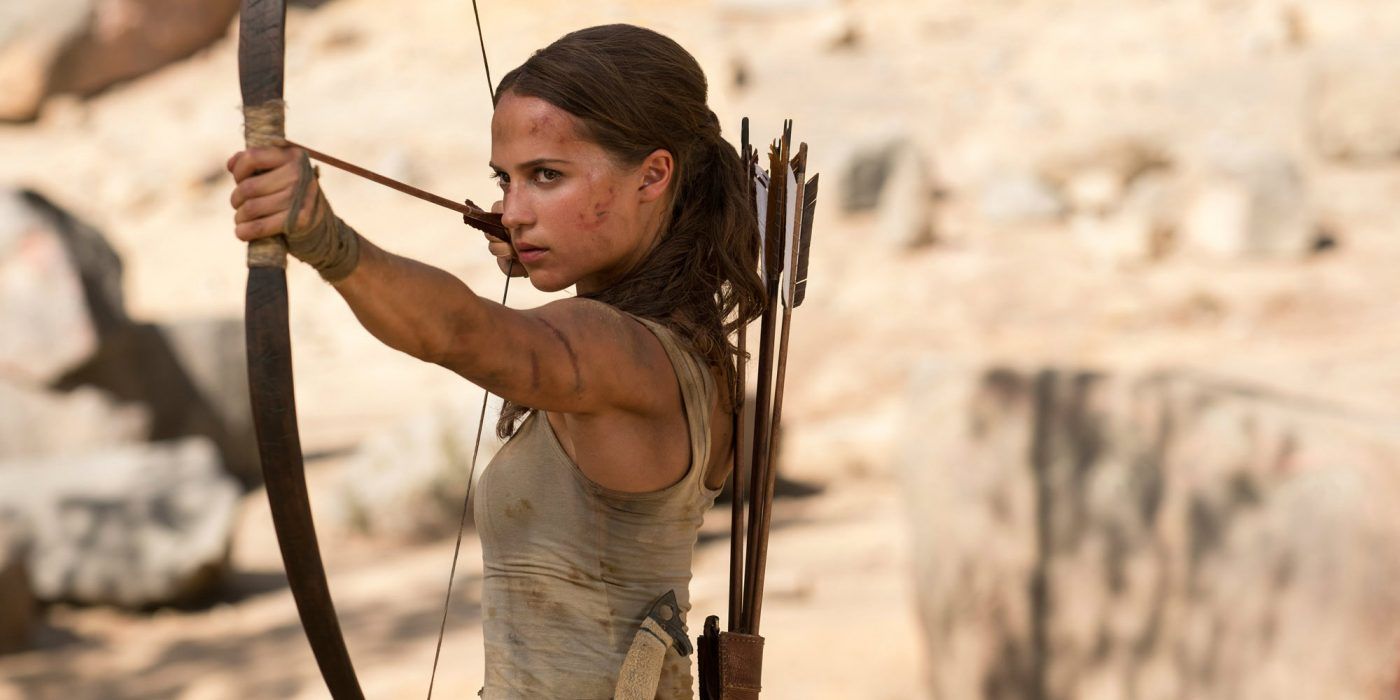 Lara Croft aims a bow and arrow