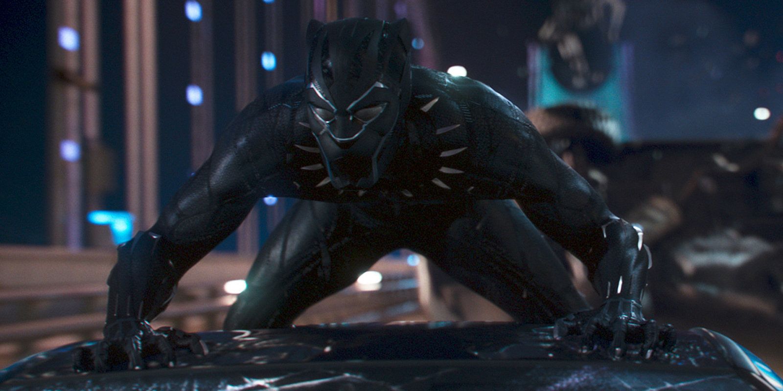 Black Panther crouches on top of a car in Black Panther.