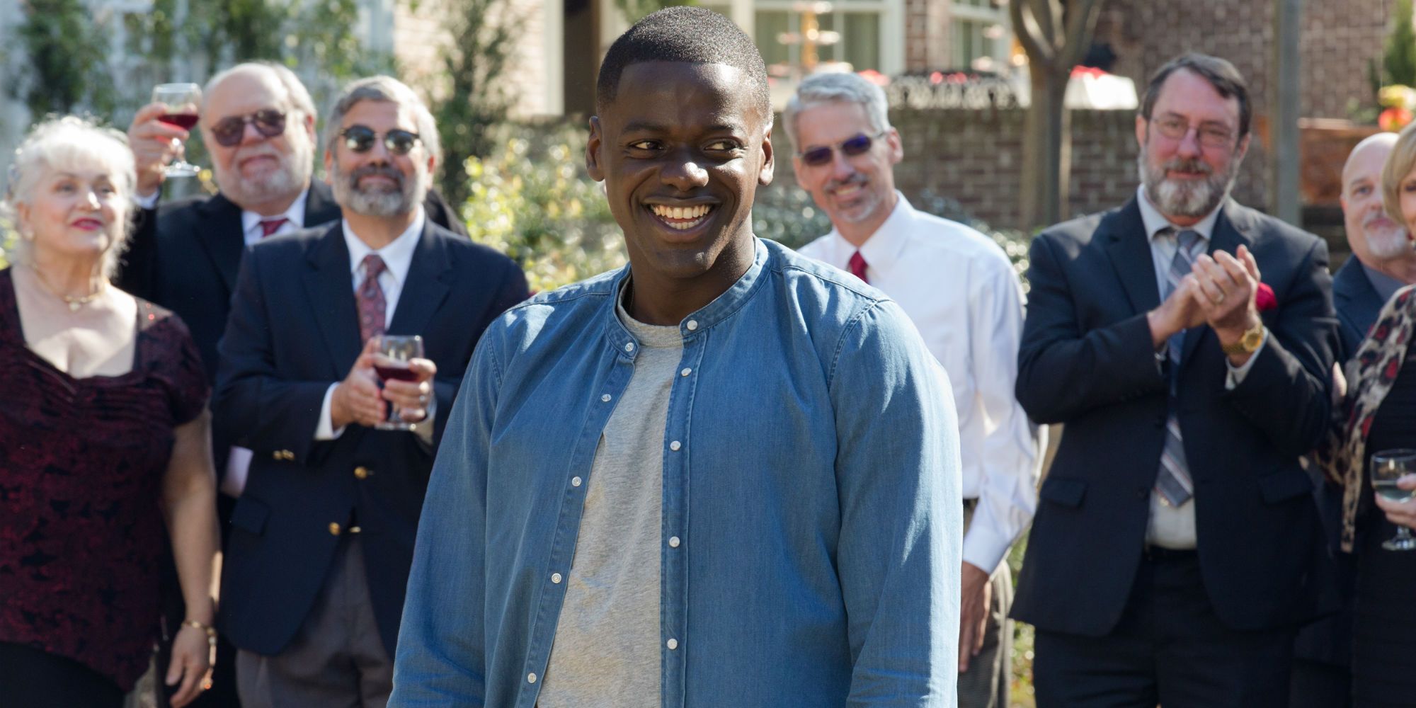 Chris (Daniel Kaluuya) smiling at the garden party in in Get Out