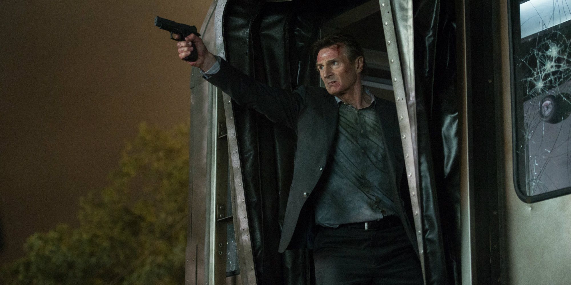 Liam Neeson pointing a gun in The Commuter