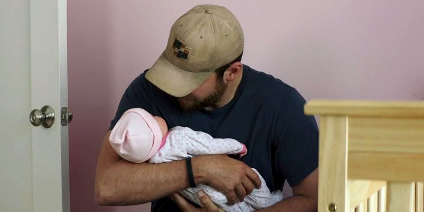 Chris Kyle holding a baby in American Sniper