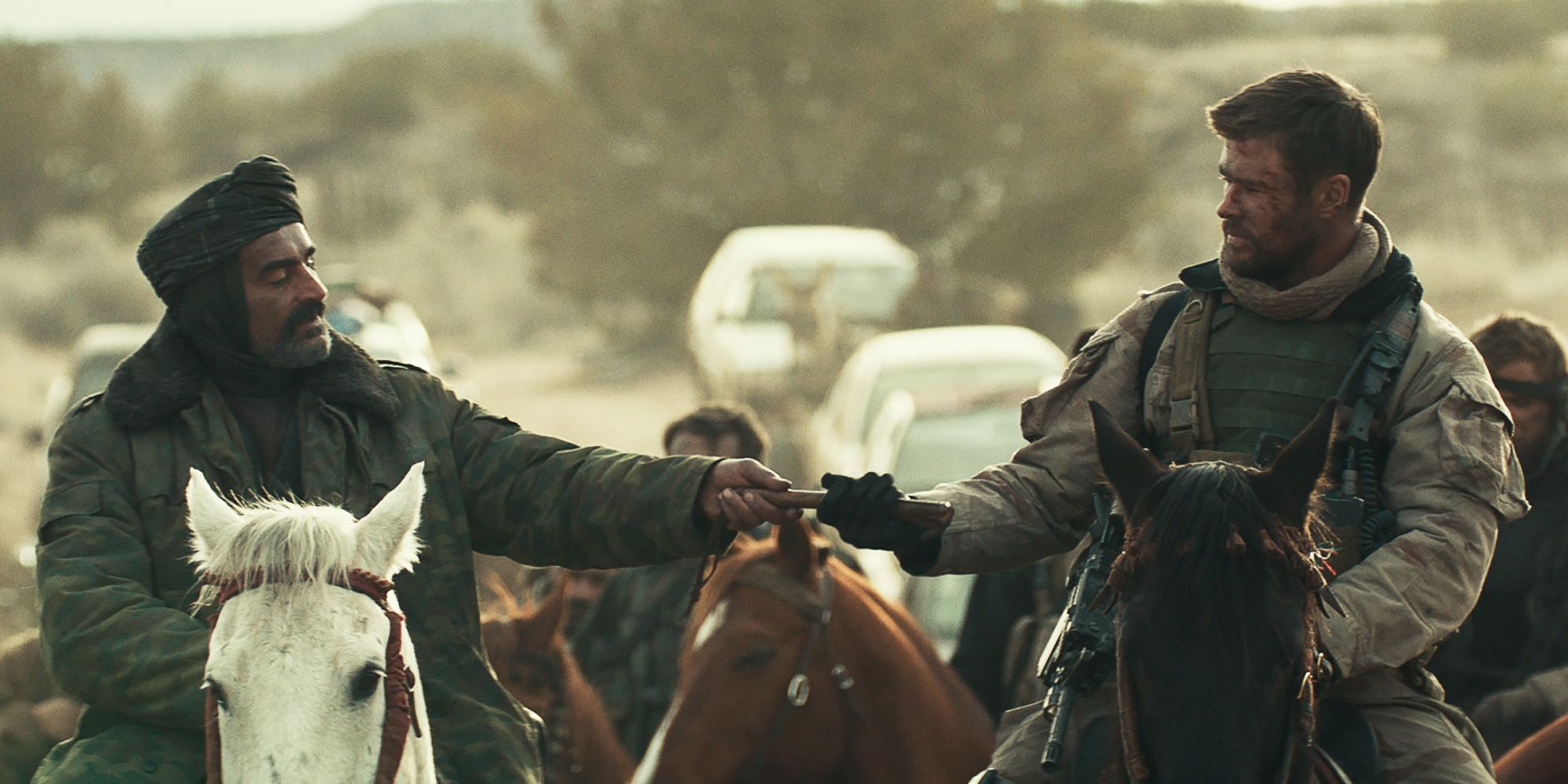 Navid Negahban and Chris Hemsworth riding horses in 12 Strong