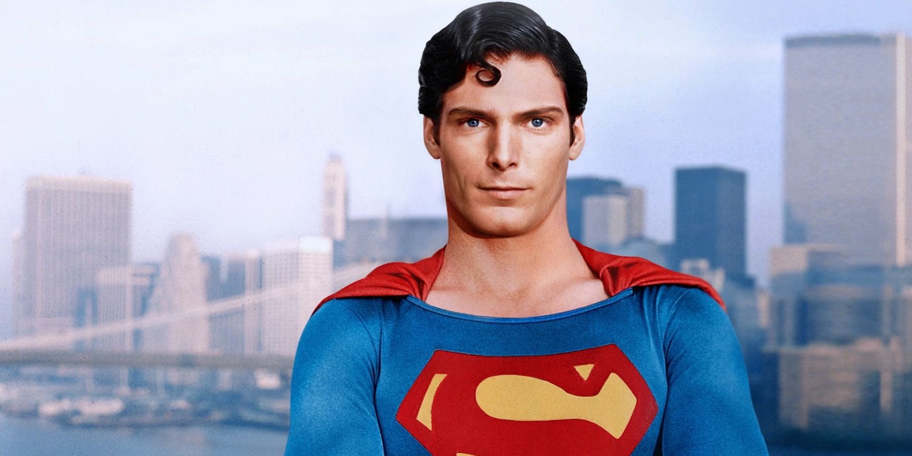 Christopher Reeve as Superman standing in front of a city skyline.