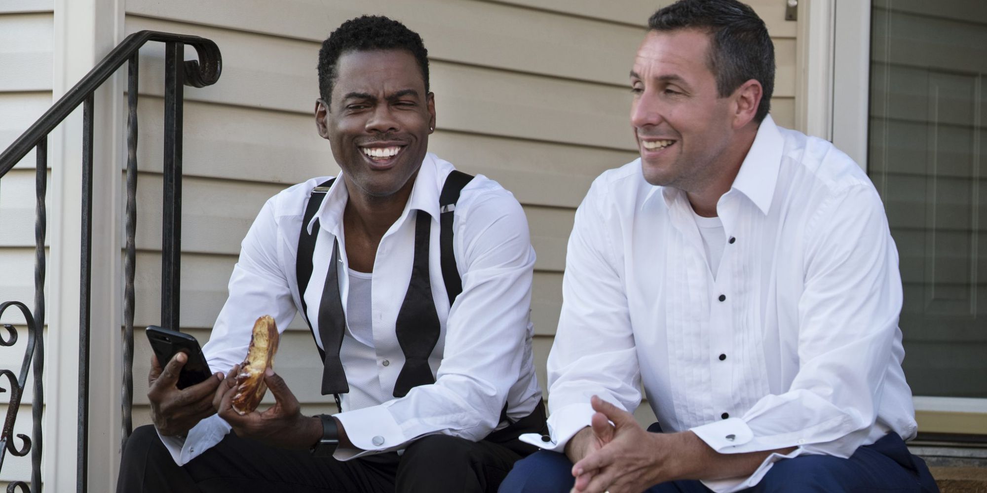 Chris Rock and Adam Sandler sitting together on a stoop in The Week Of