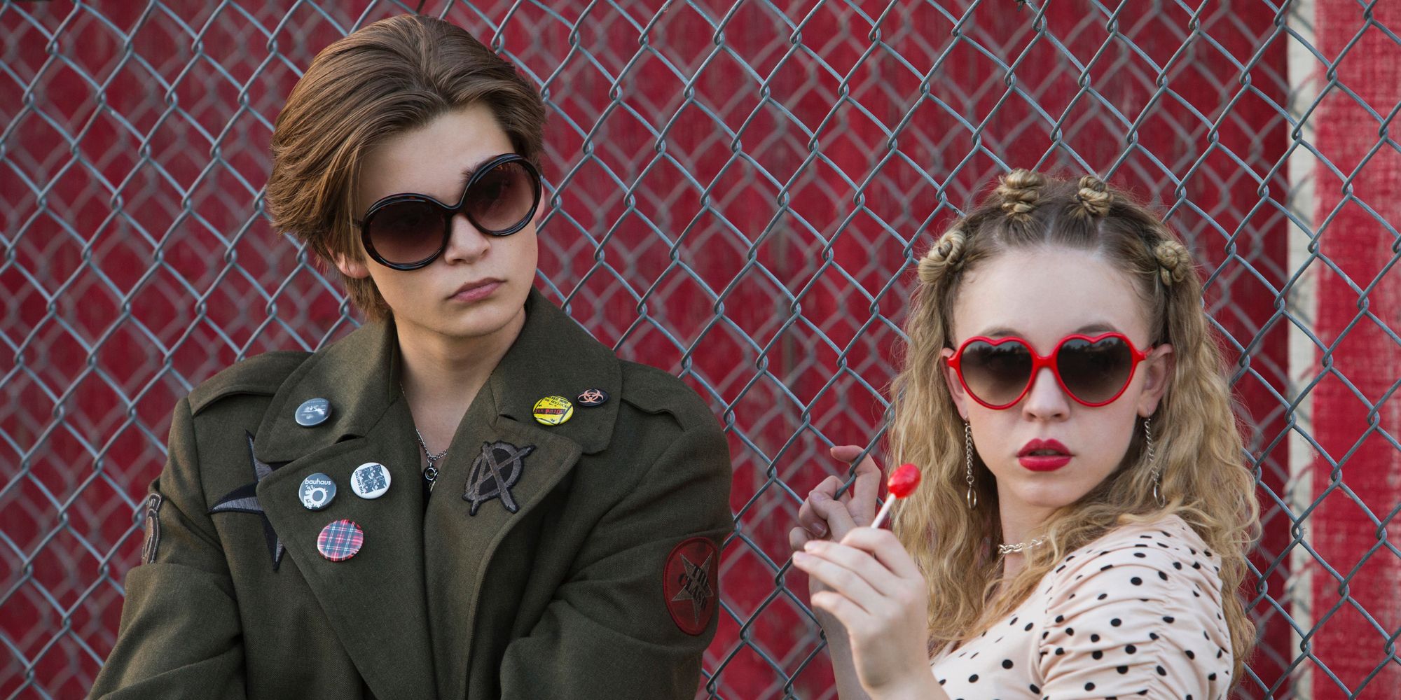 Elijah Stevenson and Sydney Sweeney in sunglasses by a fence in Everything Sucks