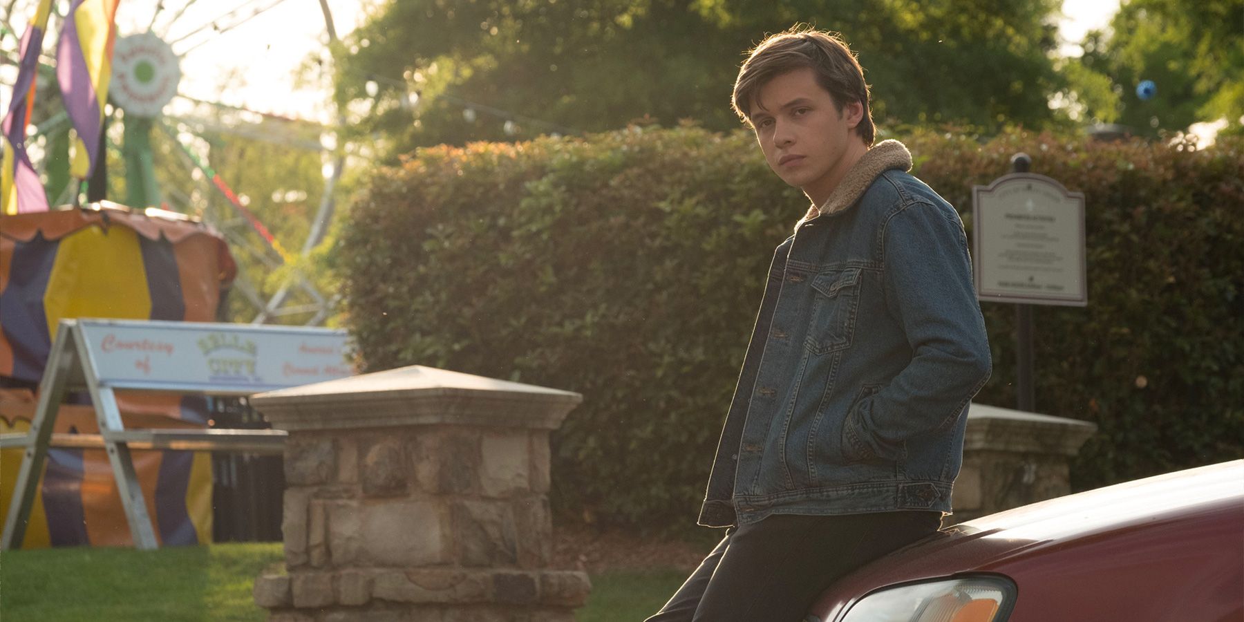 Simon sits on the hood of his car in Love, Simon.