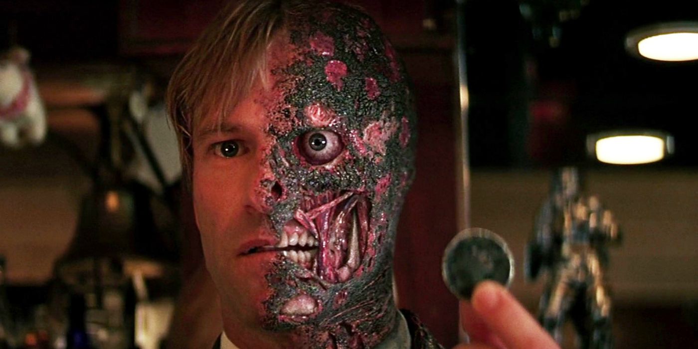 Aaron Eckhart as Harvey Dent holding a coin in The Dark Knight