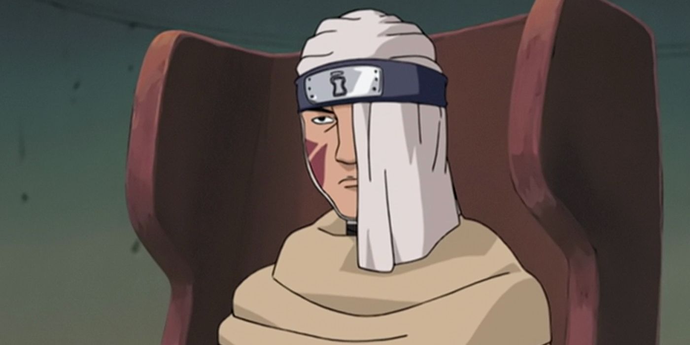 Baki sits in a chair with part of his face covered in Naruto