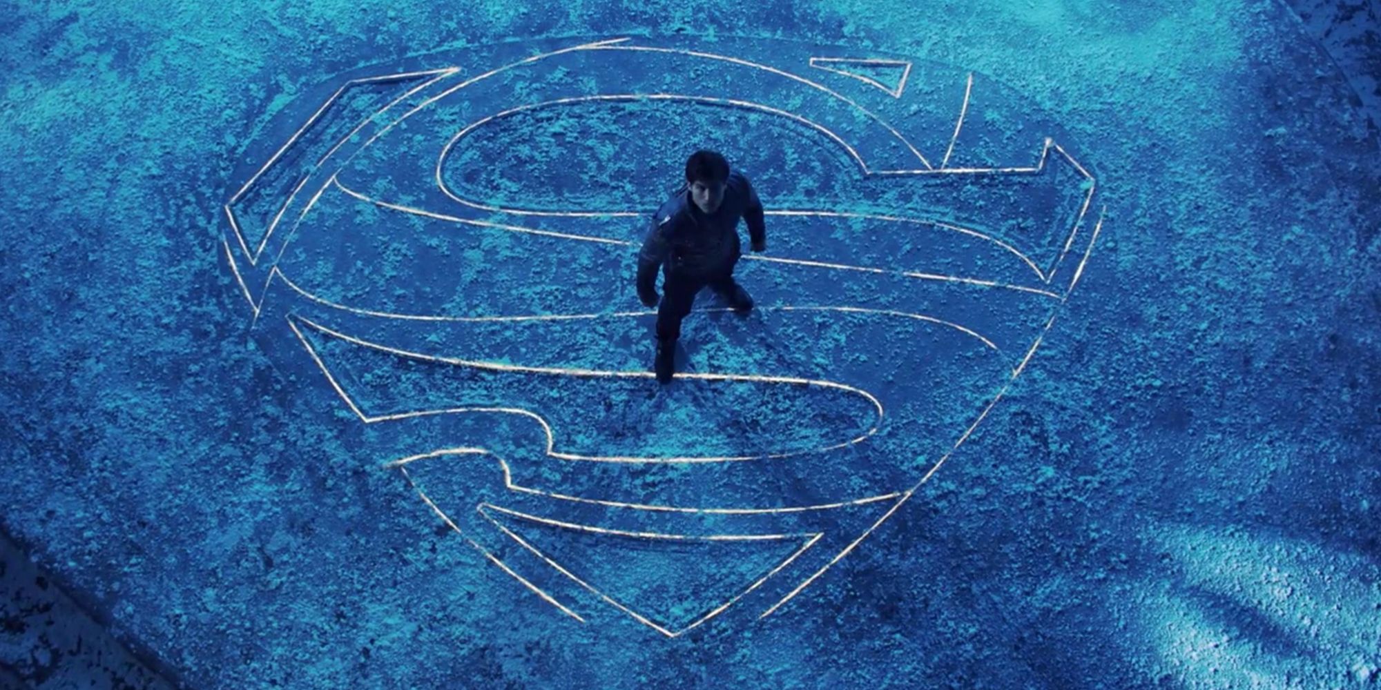 Cameron Cuffe in Krypton SYFY standing on an S symbol on the ground