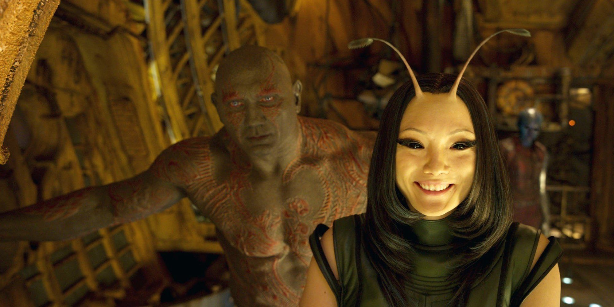 Mantis smiles and Drax stands behind her