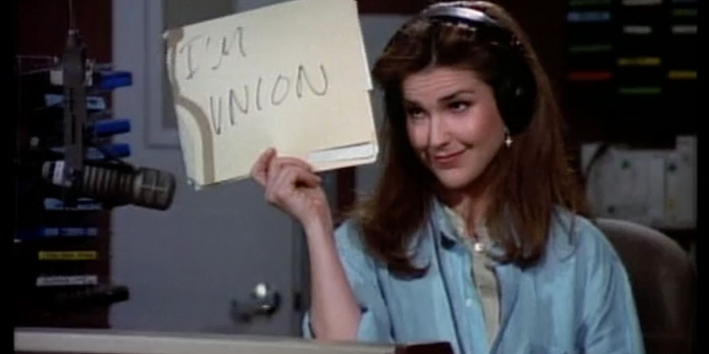 Roz Doyle holding up sign at a radio station in Frasier.