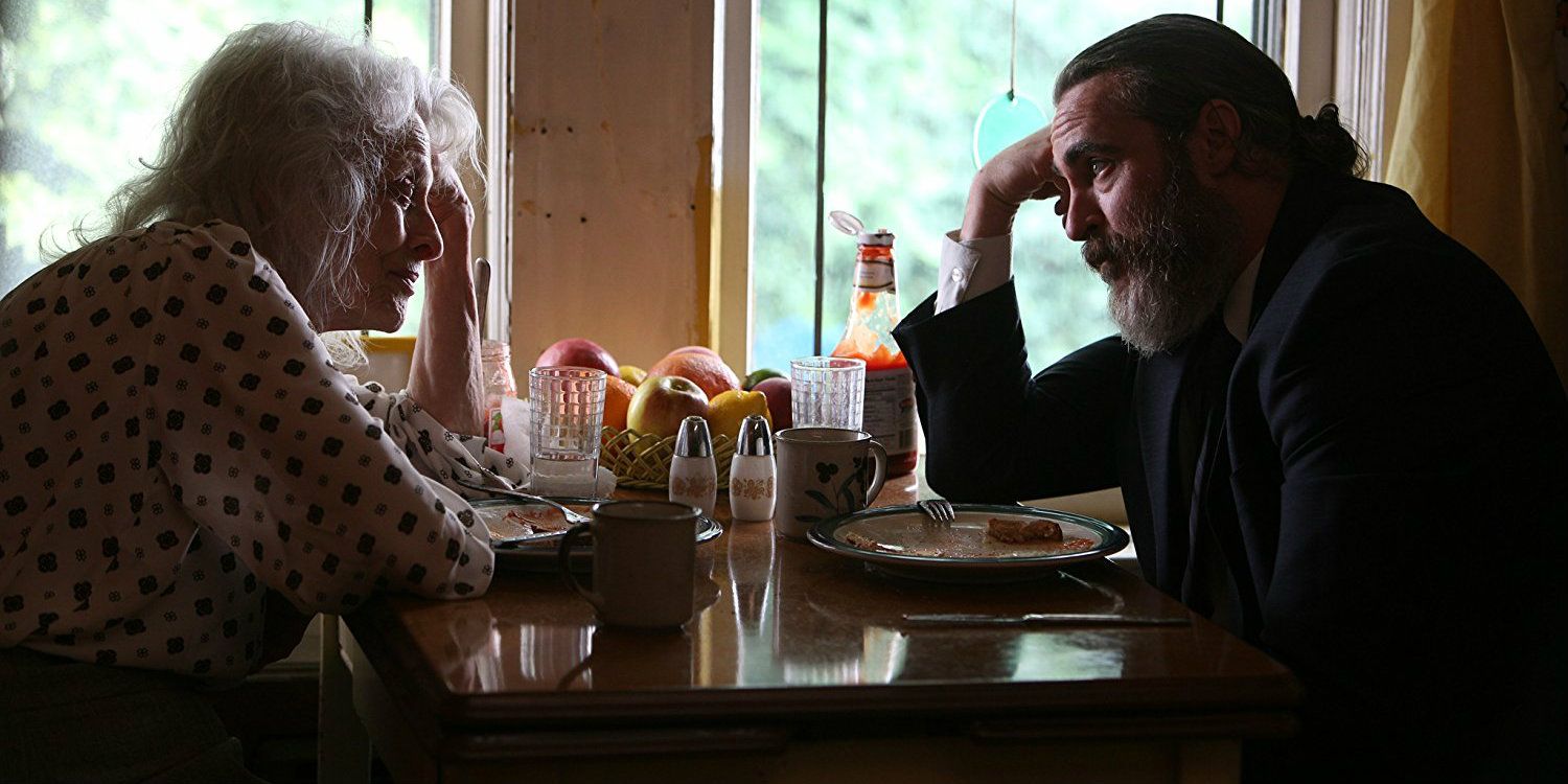 Joe sits at the table with his mother in You Were Never Really Here