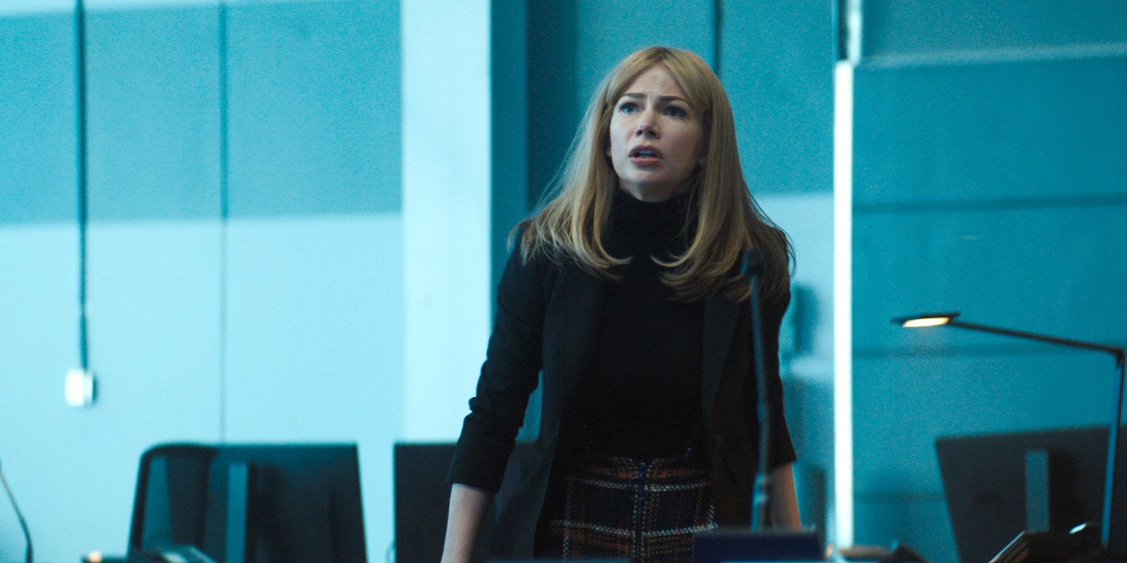 Anne Weying walks through a glass office in Venom