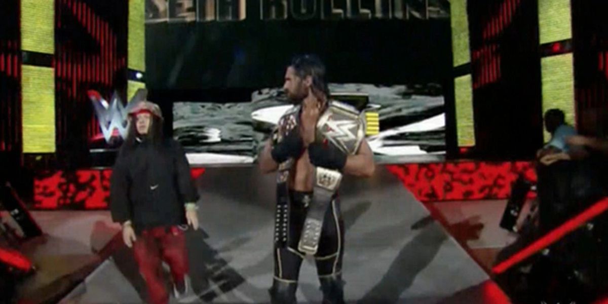 A fan joins Seth Rollins before being escorted away
