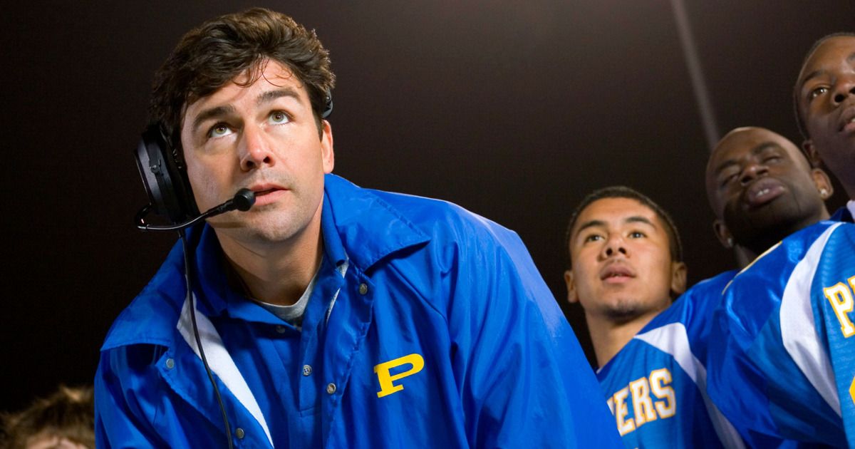 Kyle Chandler looking up and speaking on a mic in a still from Friday Night Lights