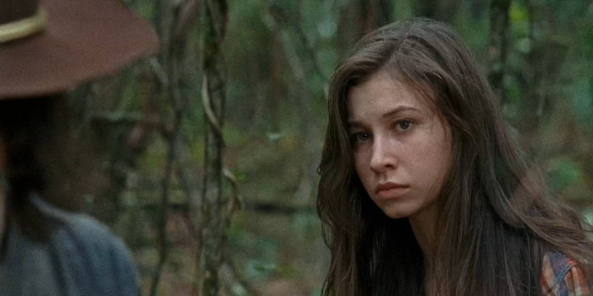 Katelyn Nacon as Enid in The Walking Dead looking upset while talking to Carl in the woods.