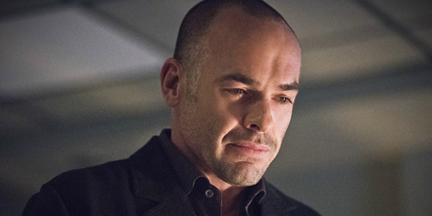 Quentin Lance looking down at something in Arrow