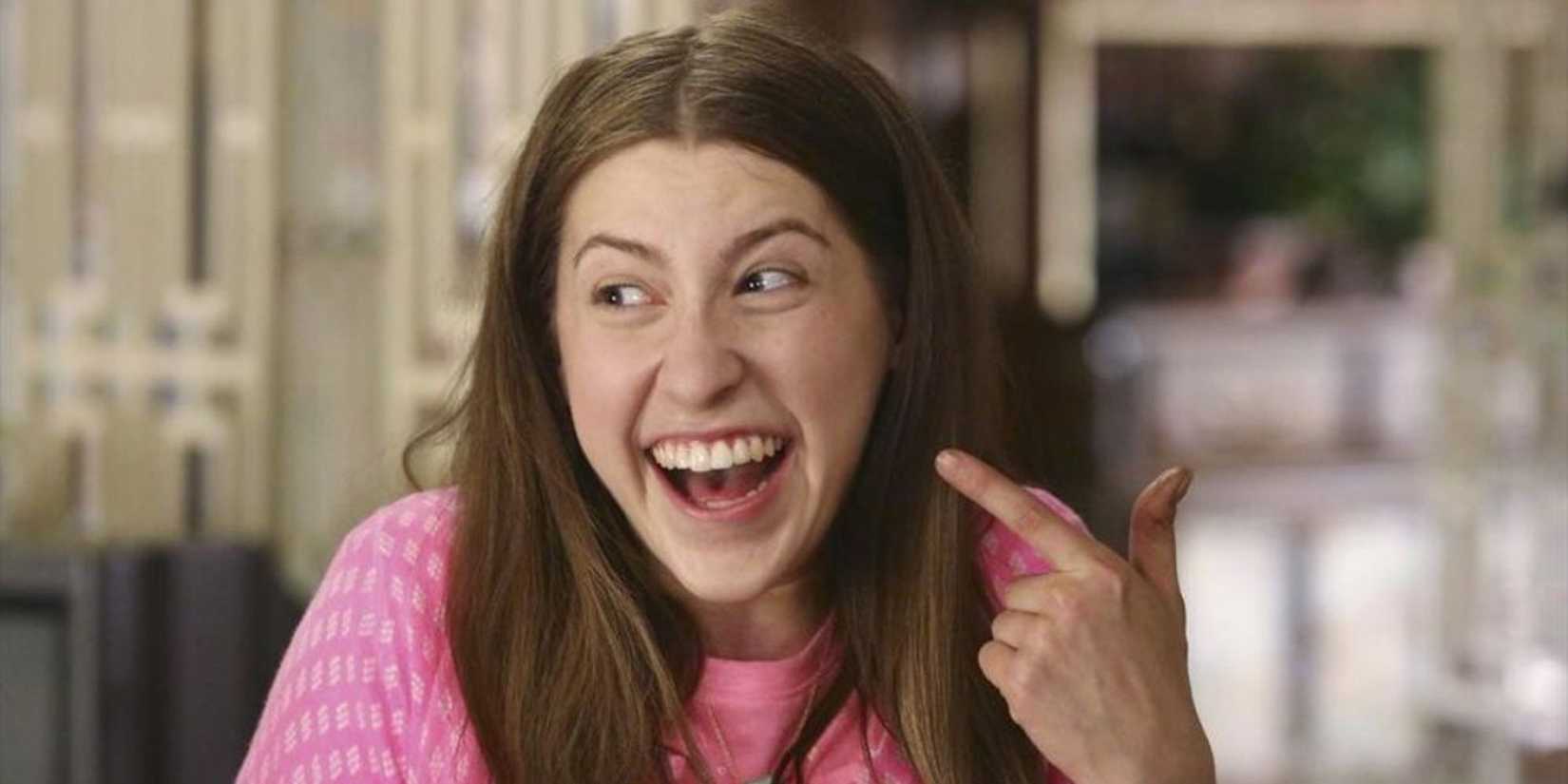 Sue Heck (Eden Sher) from The Middle pointing her finger toward her face and smiling.