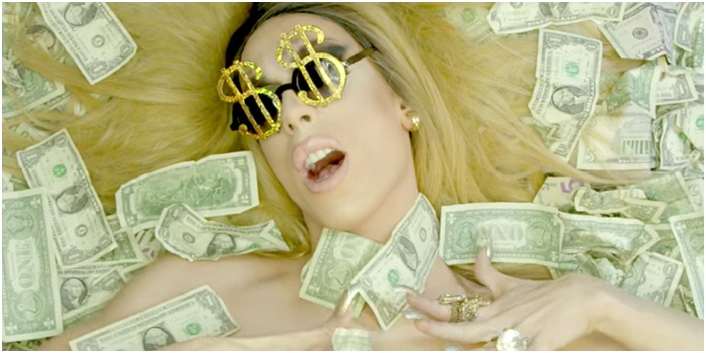 Alaska posing with money over her face from RuPaul's Drag Race 