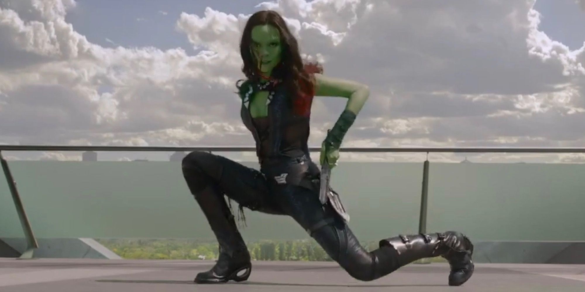 Gamora kneels on the ground to draw a weapon in Guardians of the Galaxy