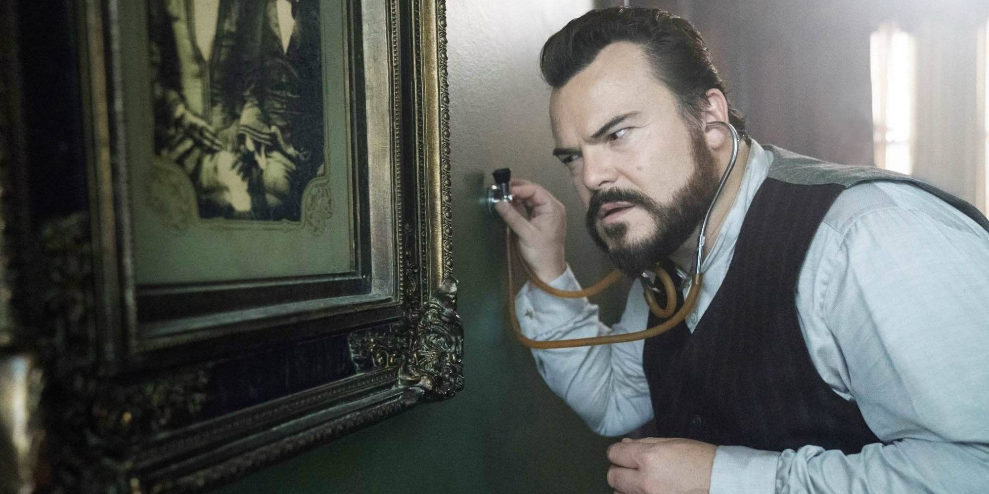 Jack Black's Jonathan listens to the wall with a stethoscope in The House With A Clock In Its Walls