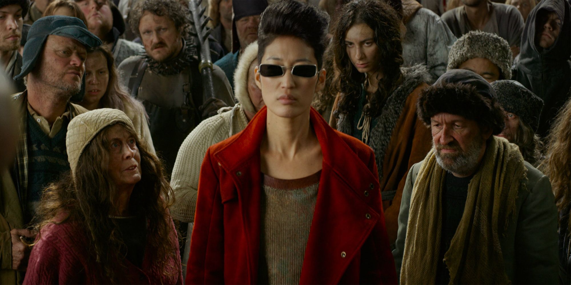 Jihae in Mortal Engines Movie standing in a crowd wearing sunglasses 