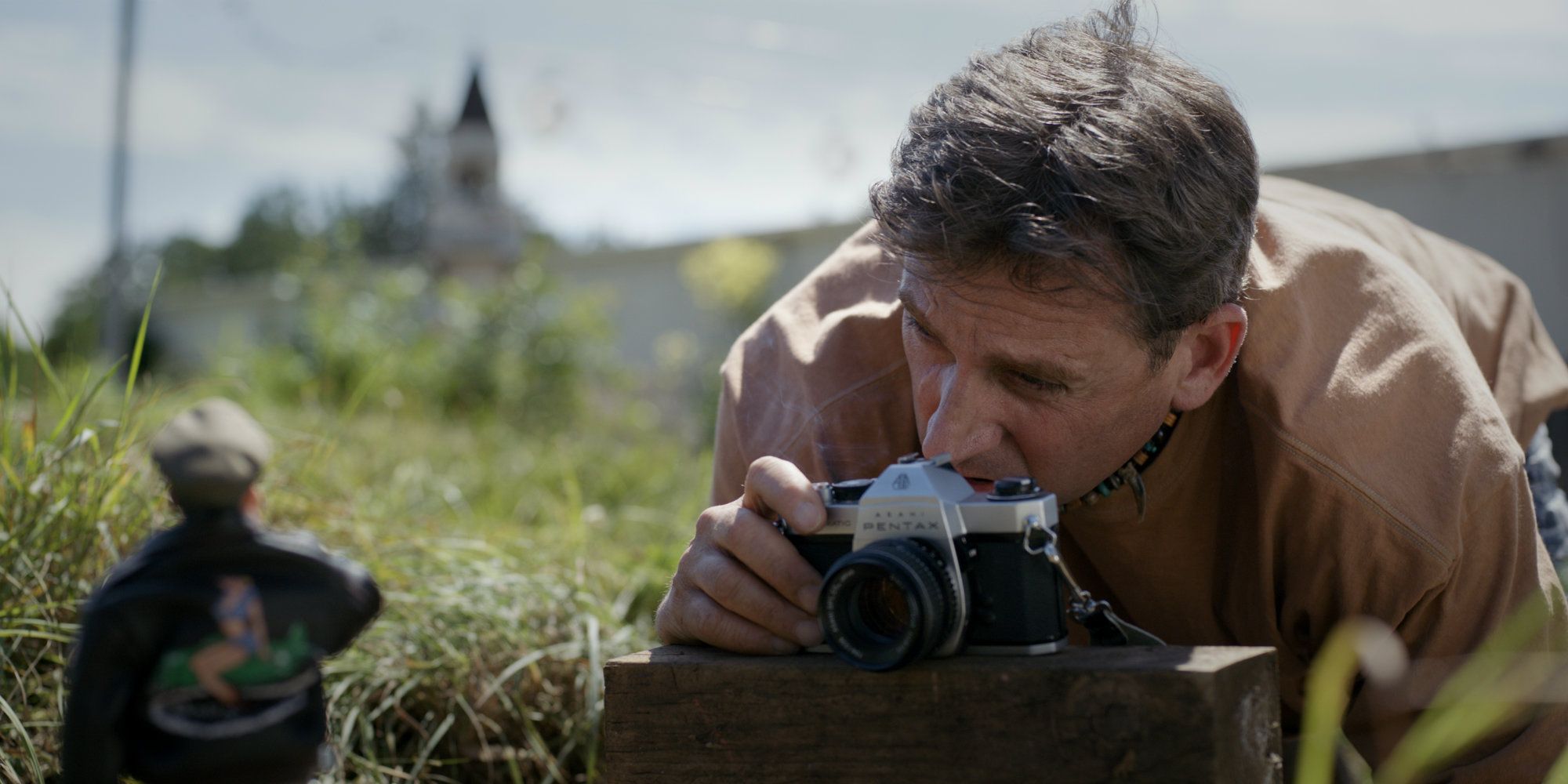 Steve Carell photographing an action figure in Welcome to Marwen