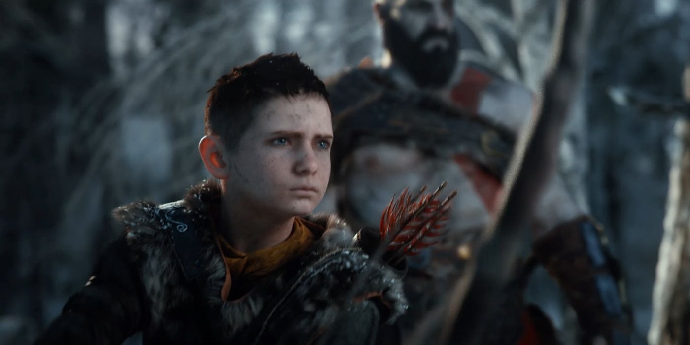 Atreus focusing on something offscreen as Kratos stands behind him in God of War.