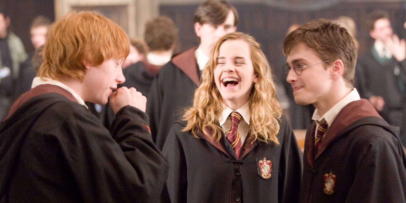 Ron, Hermione and Harry in Hogwarts robes laughing