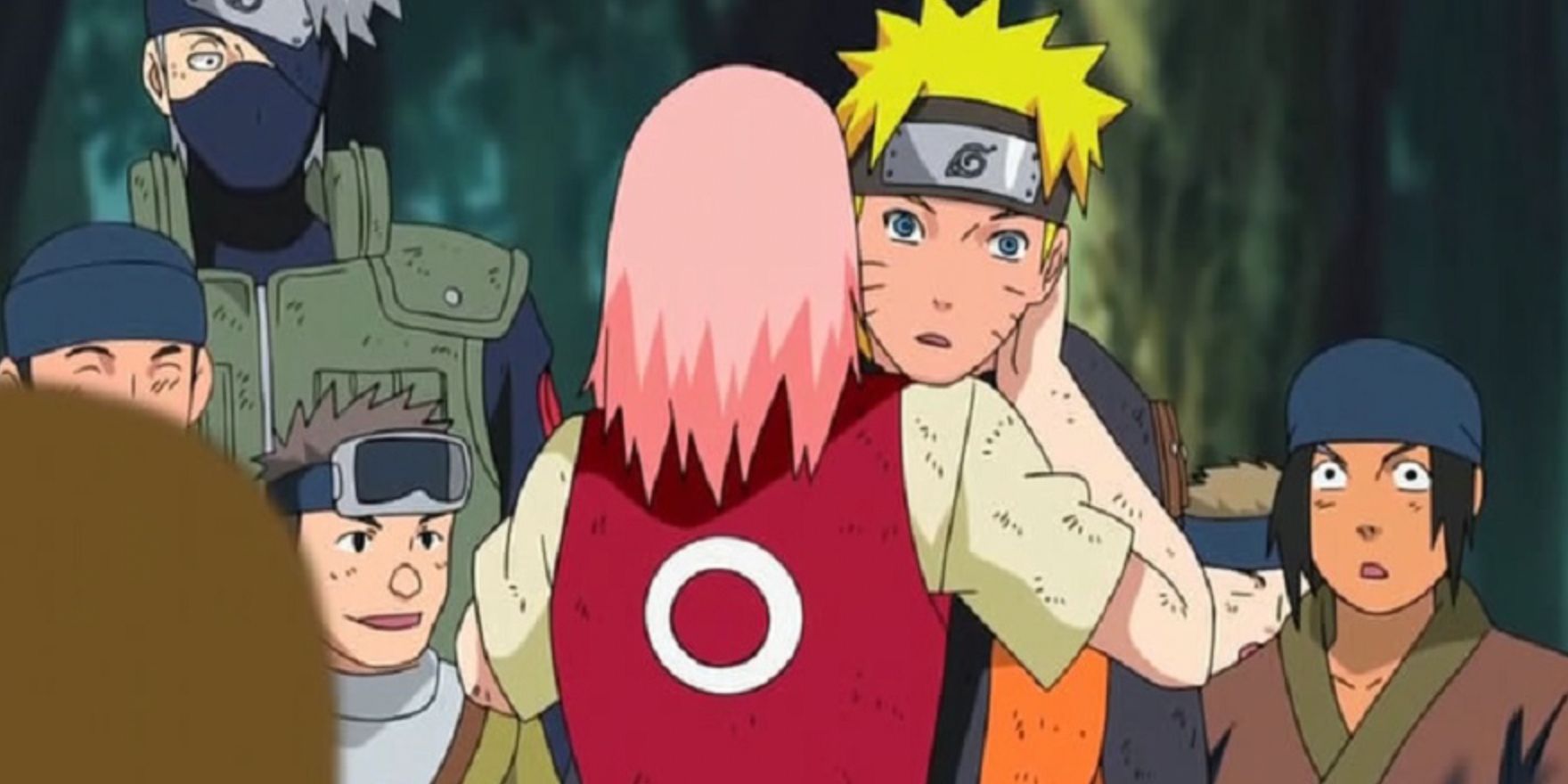 Sakura hugs Naruto in front of a crowd
