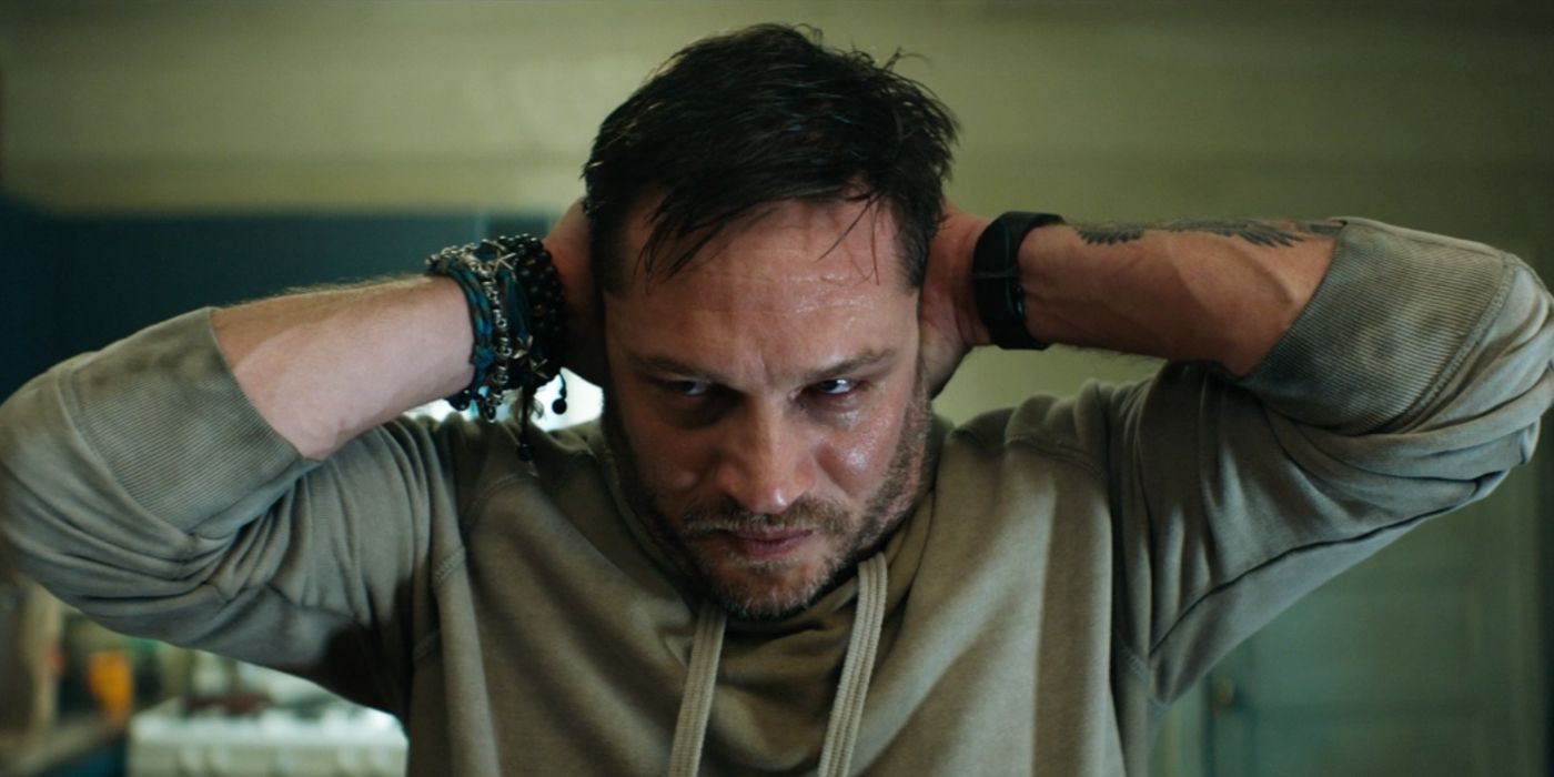 Tom hardy as Eddie Brock holding his head and stressed in Sony's Venom