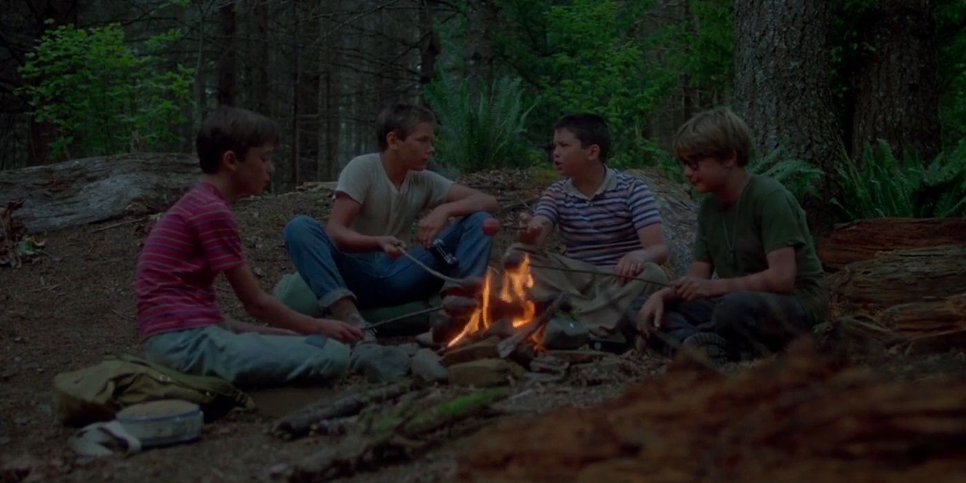 The kids in Stand by Me sit around a camp fire