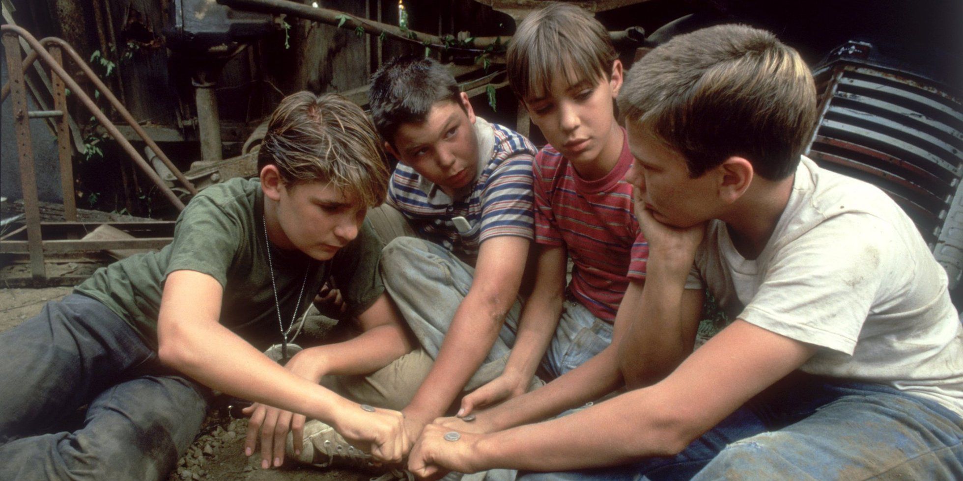 Four boys join their hands together in Stand By Me 