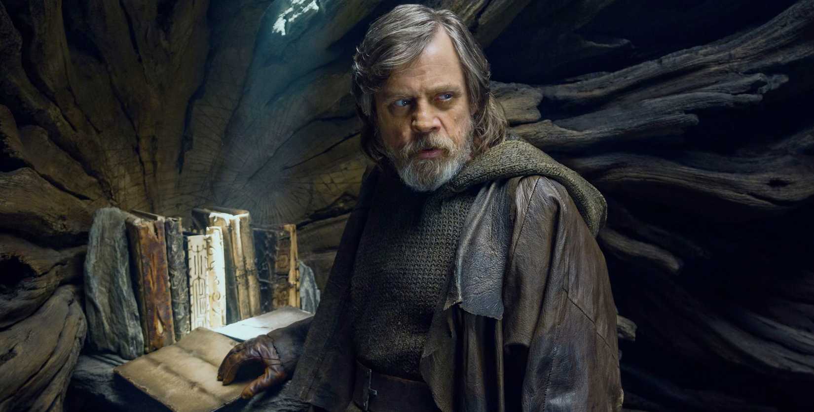 Luke Skywalker in Star Wars: The Last Jedi with the tree and the ancient Jedi texts