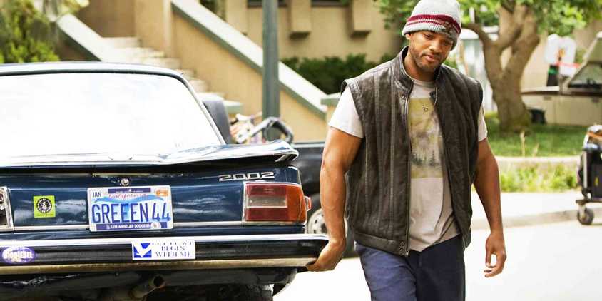 Will Smith as John Hancock in Hancock holding a car with one hand