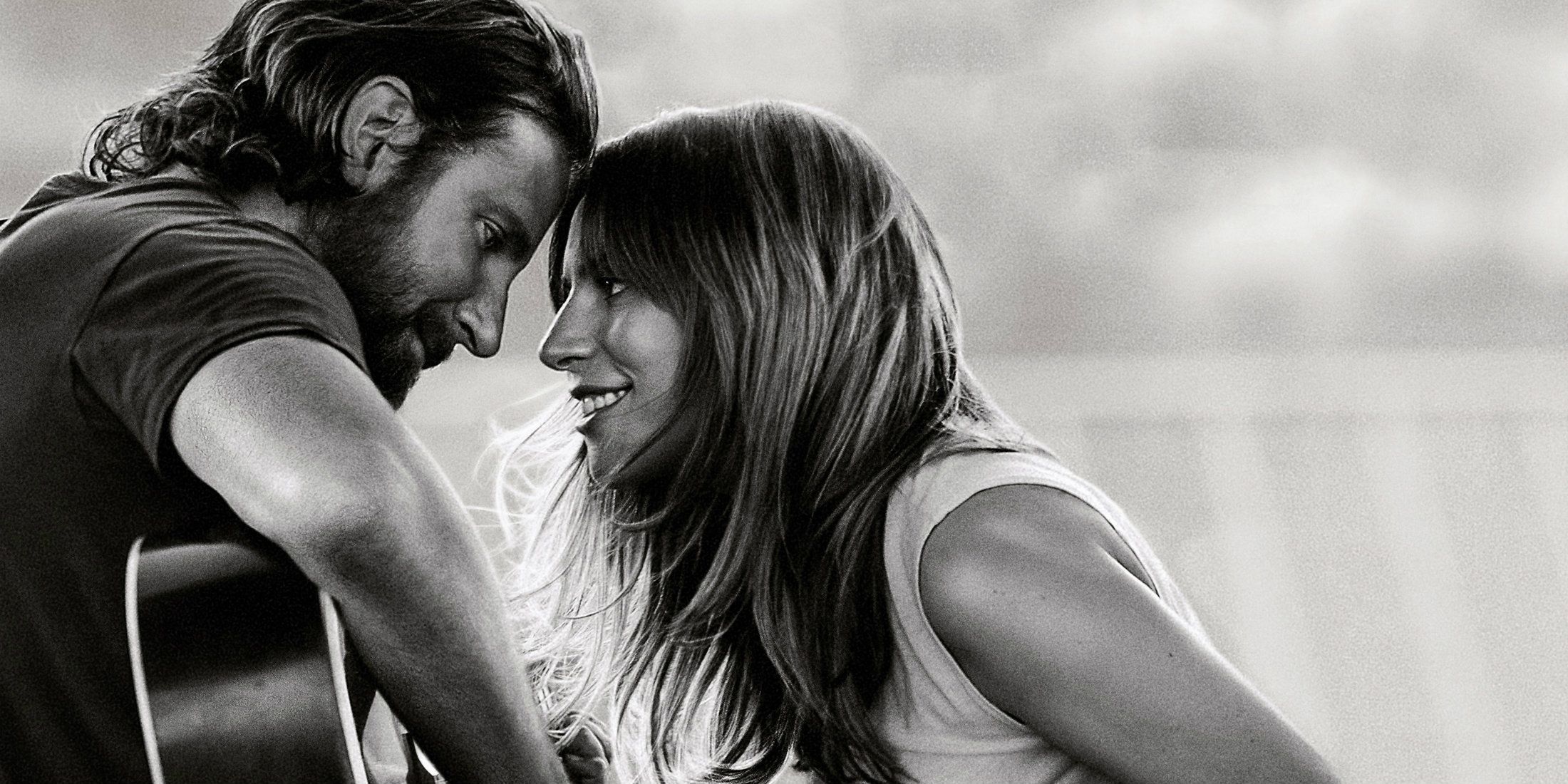 A Star Is Born poster featuring Bradley Cooper playing a guitar while staring into Lady Gaga's eyes