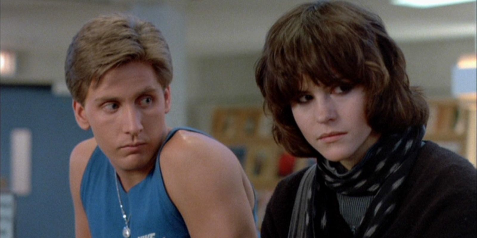 Emilio Estevez and Ally Sheedy sit and look in a library in The Breakfast Club.