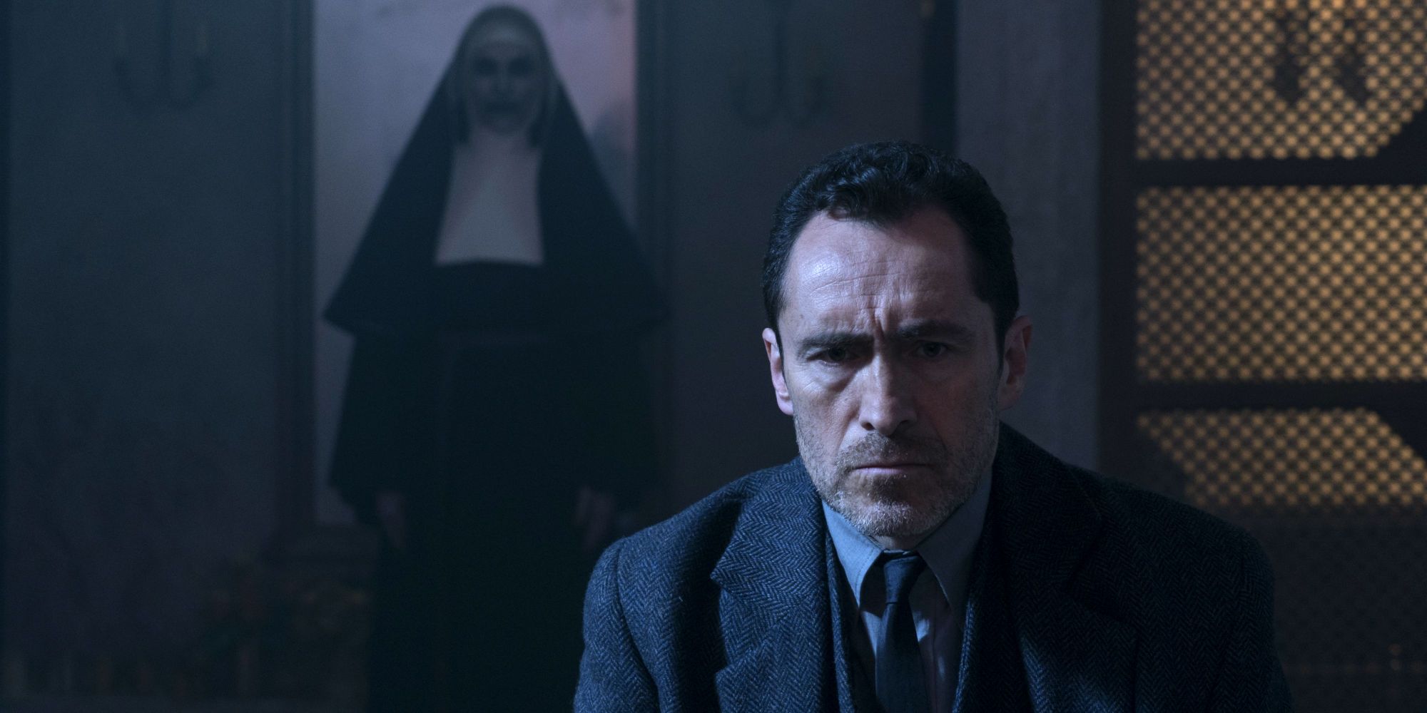 The Nun hovering behind Father Burke in The Conjuring Universe.