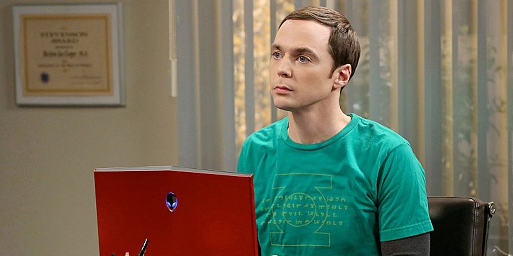 Sheldon Cooper atrás de sua mesa e parecendo confuso em The Big Bang Theory.