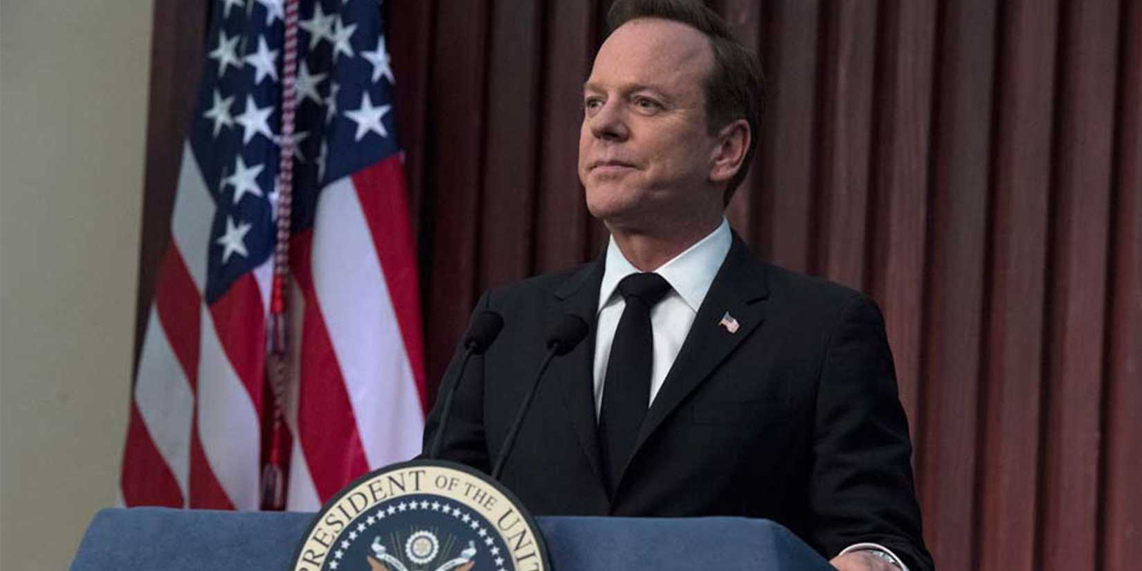 Kiefer Sutherland as Thomas Kirkman standing in front of an American flag and behind a podium in Designated Survivor.