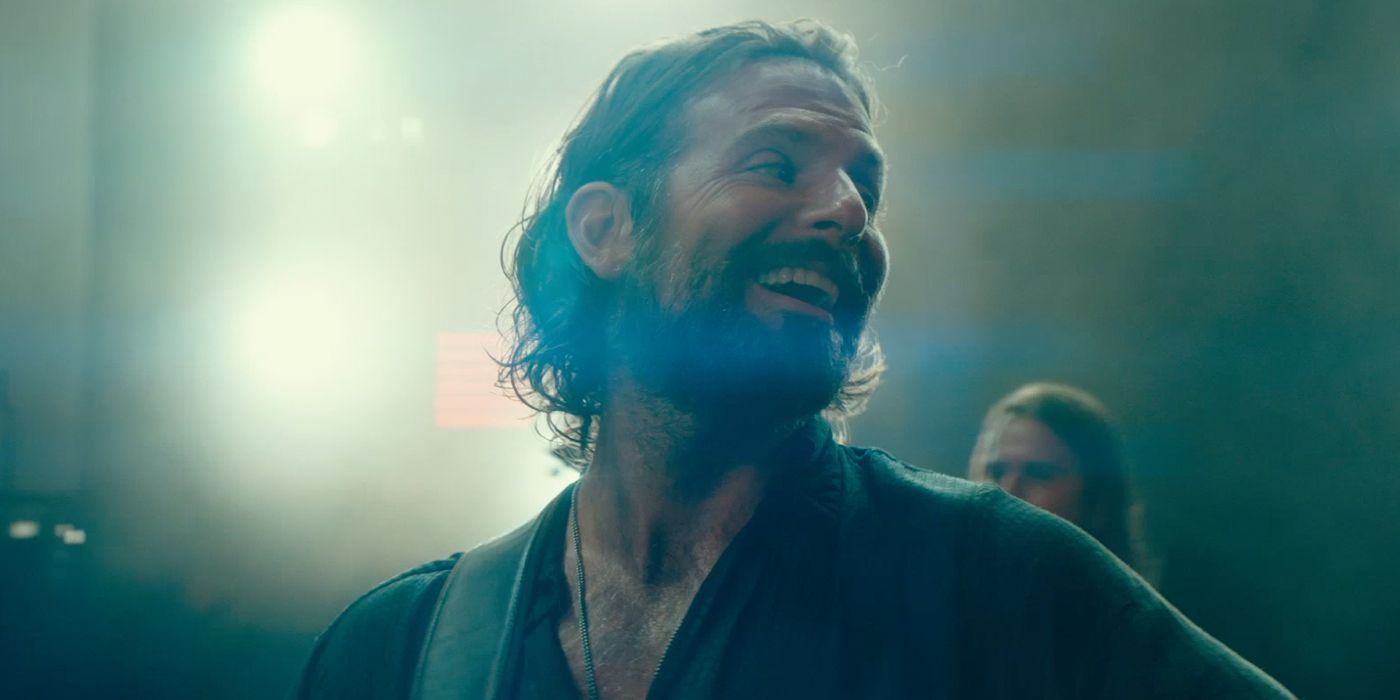 Bradley Cooper sonriendo en el escenario en A Star Is Born
