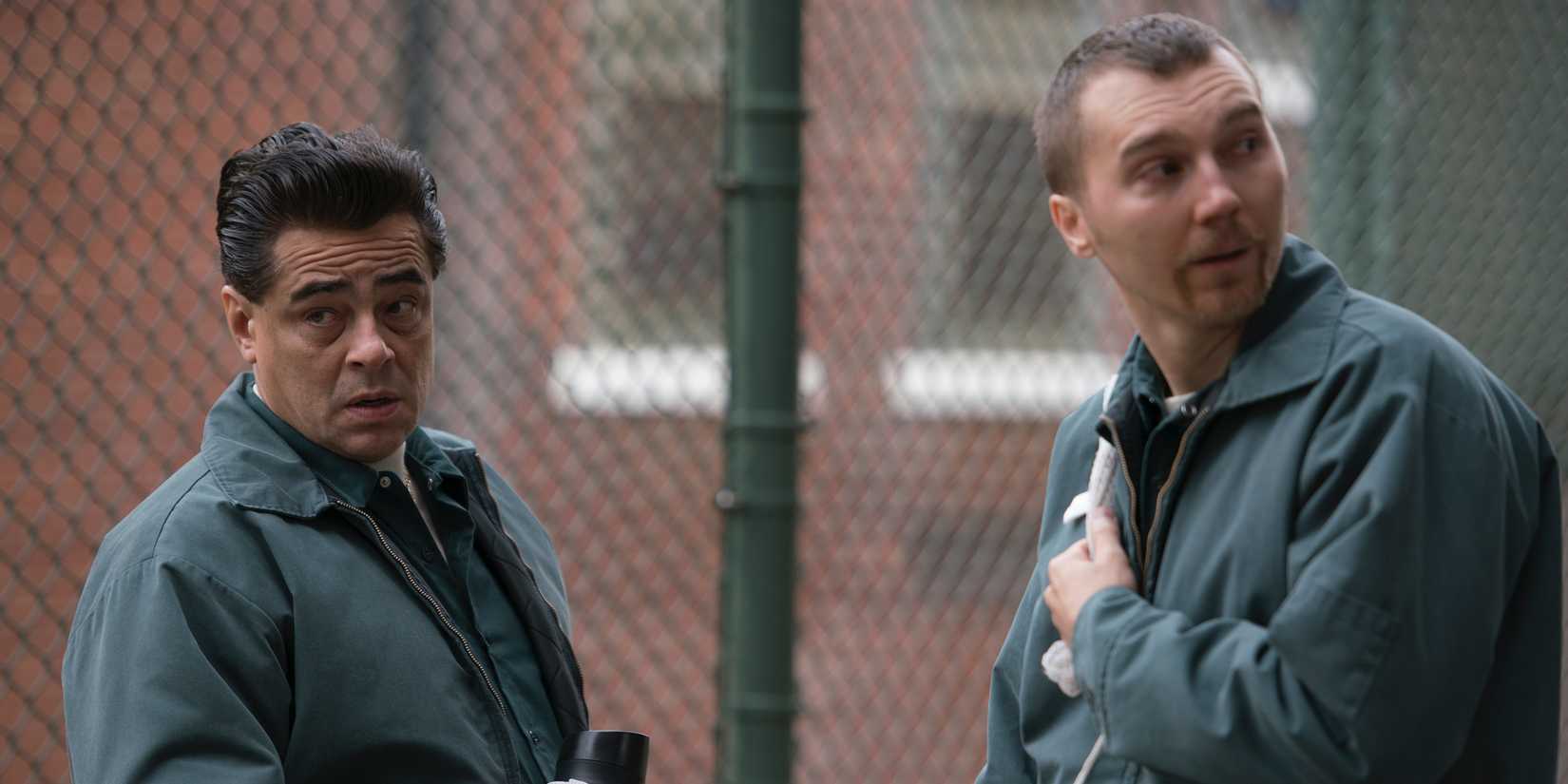Benicio Del Toro and Paul Dano as Richard and David talking next to a fence in Escape at Dannemora
