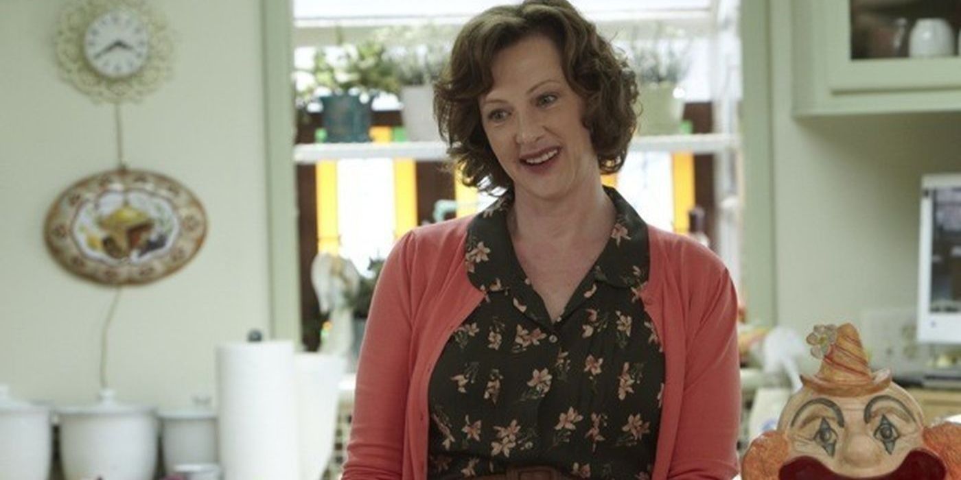 Sheila with odd grin in kitchen in Shameless