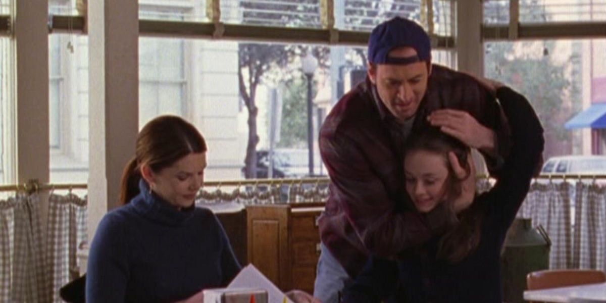 Lorelai with Luke who hugs Rory at Luke's diner on Gilmore Girls