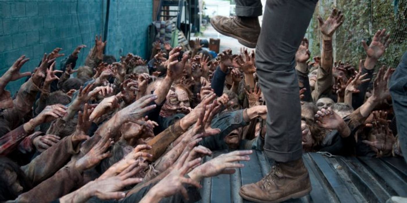 Os caminhantes de The Walking Dead alcançando Glenn.