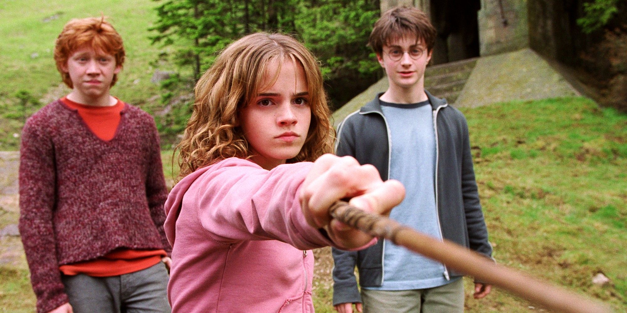 Hermione pointing a wand with Ron and Harry standing behind her in Harry Potter