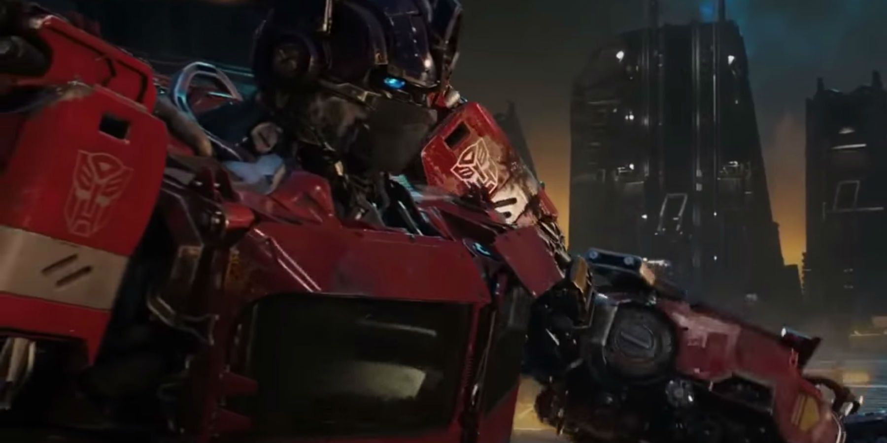 Optimus Prime está em frente aos edifícios imponentes de Cybertron ao fundo